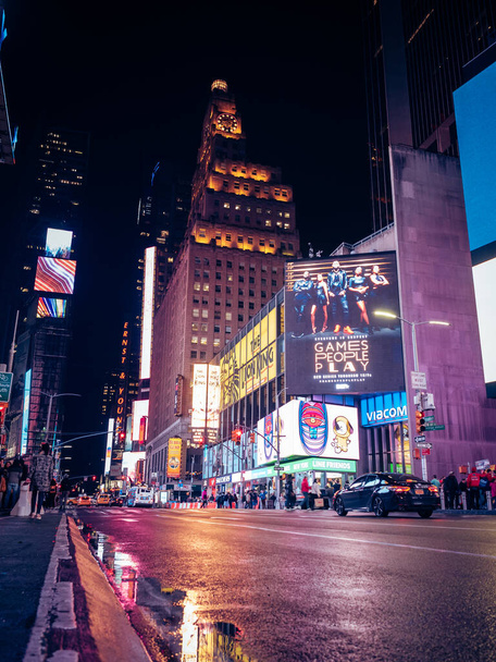 A vertical shot of the nightlife in New York City streets with the buzz of busy life with billboards - Φωτογραφία, εικόνα