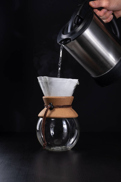 A vertical closeup of the pouring boiling water into the coffee maker. - Foto, Imagen