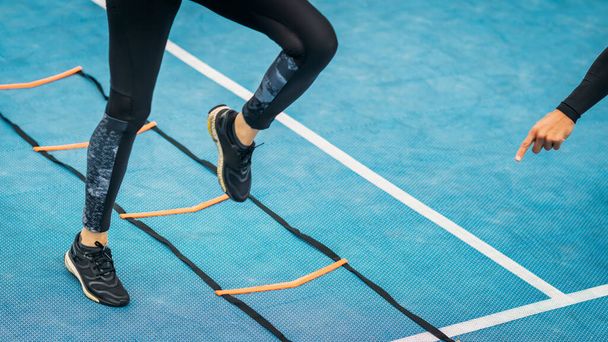Fiatal nő gyakorló személyes fitness edző segítségével mozgékonysági létra. Agilitás javítása. - Fotó, kép