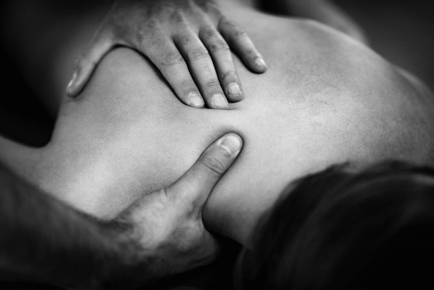 Close up image of physical therapist massaging female clients shoulder.  - Фото, зображення
