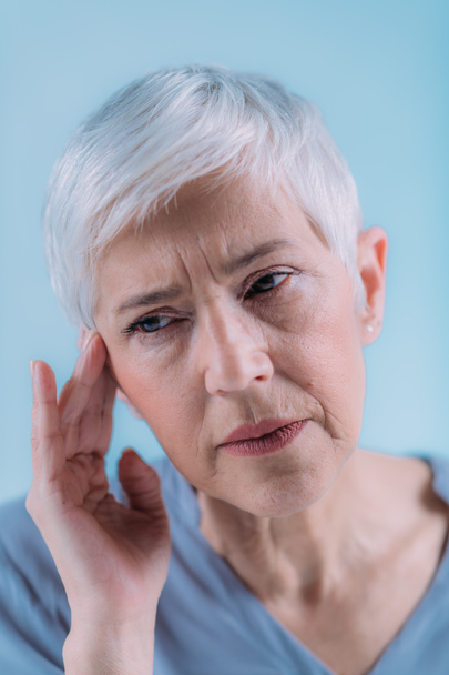 Tinnitus. Senior woman suffering from tinnitus. - Фото, изображение
