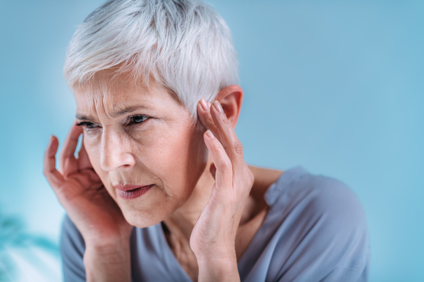Senior woman suffering from tinnitus or ringing in her ears. - Zdjęcie, obraz