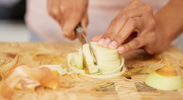 Every meal begins with a base of onions. a woman cutting an onion - Foto, Imagem