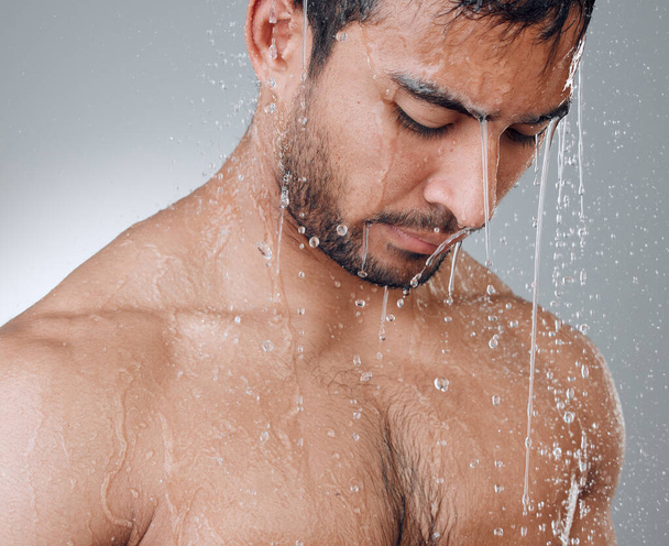 Bad day Take a warm shower. a young man taking a shower against a grey background - 写真・画像