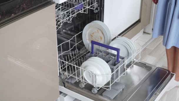 女性の手は食器洗い機の閉鎖の棚の底に汚れたプレートを置きます.高品質4k映像 - 映像、動画