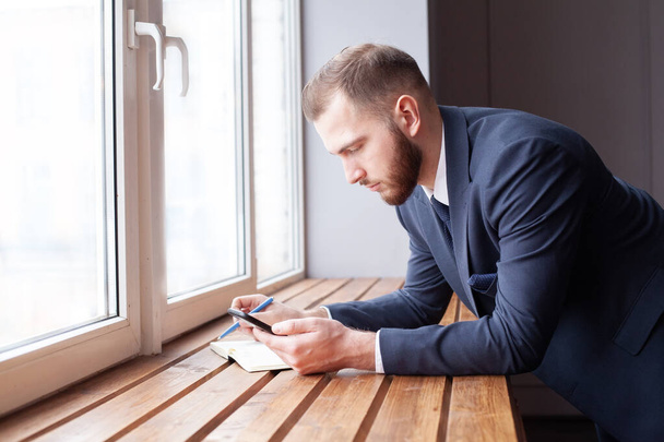 Bisiness férfi használja az internetet okostelefonon beltéri - Fotó, kép