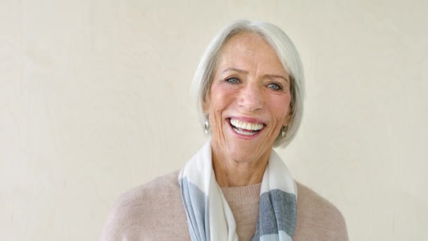 Portrait of smiling senior woman against a studio, copy space background. Sequence of mature lady using phone and technology to text and browse online. Showing dentures and cheerful facial expression. - Filmagem, Vídeo