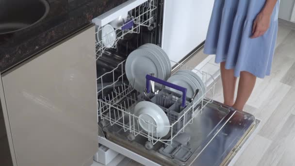 Bir kadın bulaşık makinesinden temiz tabaklar çıkarıyor. Yüksek kalite 4k görüntü - Video, Çekim