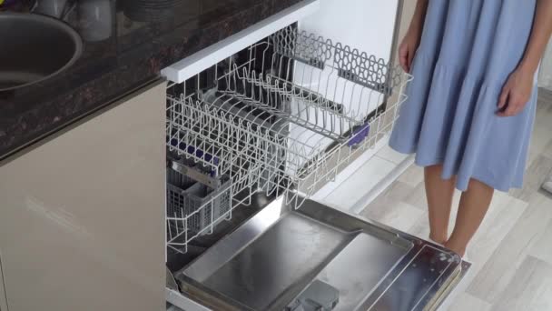 Una mano de mujer empuja el estante superior y cierra el lavavajillas vacío. Imágenes de alta calidad 4k - Metraje, vídeo
