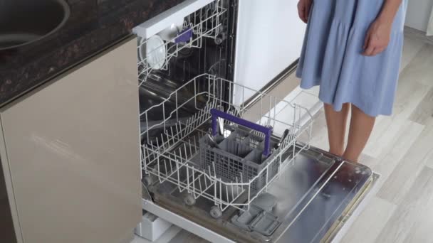Ev hanımı bulaşık makinesinden temiz çatal ve kaşıklar çıkarır. - Video, Çekim