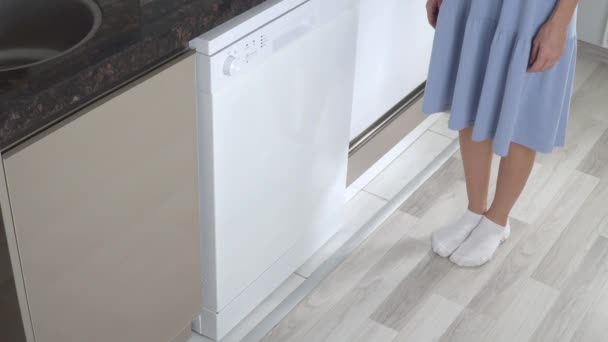 Bir kadın bulaşık makinesini yıkadıktan sonra açıyor ve temiz tabaklarla alt rafı itiyor.. - Video, Çekim