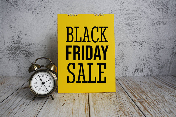 Black Friday Sale text message and alarm clock on wooden background - Foto, imagen