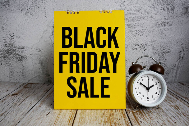 Black Friday Sale text message with alarm clock on wooden background - Φωτογραφία, εικόνα