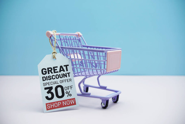 Great Discount Special offer 30% off text message on price tax with shoppint trolley cart on blue and pink background - Photo, Image