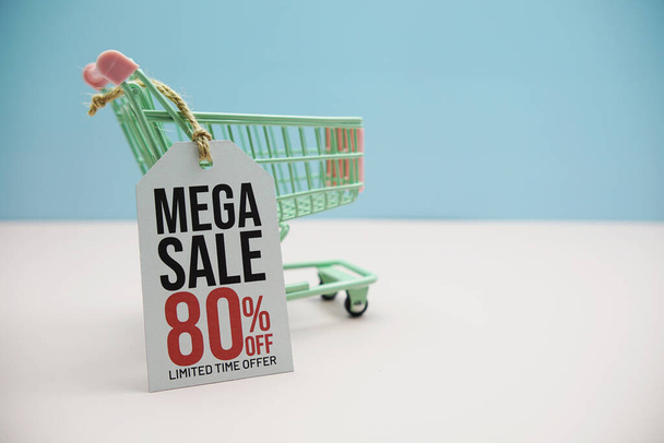 Mega Sale 80% off text message on price tax with shoppint trolley cart on blue and pink background - Foto, imagen