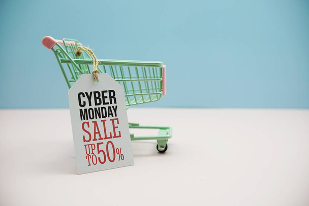 Cyber Monday Sale 50%  text message on price tax with shoppint trolley cart on blue andp pink background - Foto, afbeelding