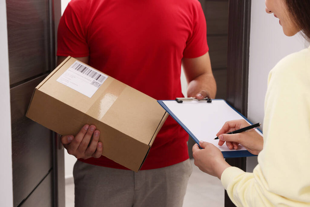 Woman signing for delivered parcel at home, closeup - Foto, Imagem