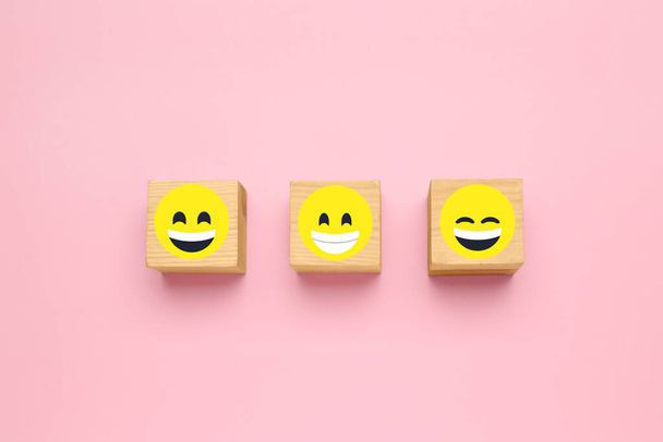 Wooden cubes with different emoticons on pink background, flat lay - Fotografie, Obrázek