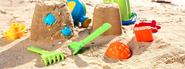 Set of plastic beach toys on sand near sea. Banner design - Foto, afbeelding