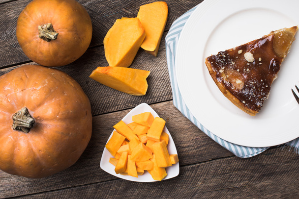 Pumpkins and pie on plate - Фото, изображение