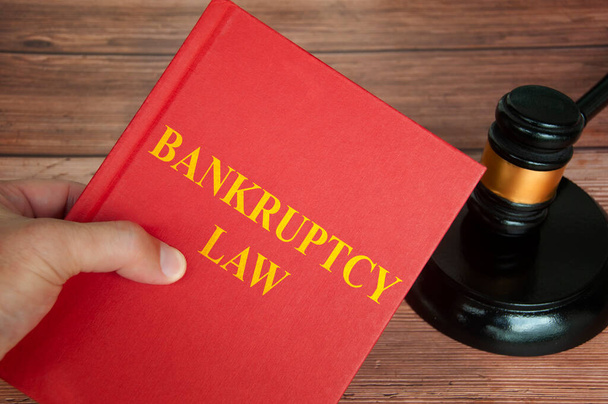 Bankruptcy law text on law book with judge gavel on wooden desk. Law concept - Foto, Imagen