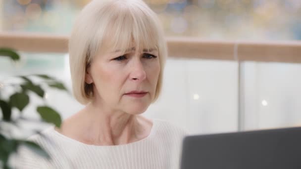 Close-up frustrated mature businesswoman looking at laptop screen reading email stunned shocked by unpleasant bad news emotion excited woman professional worker finds mistake in computer application - Πλάνα, βίντεο