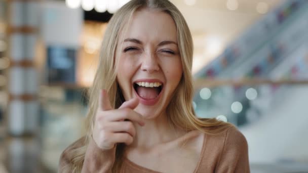 Attractive caucasian girl with long blonde hair points fingers at camera smiles toothy happy you are right gesture agree sign. Young woman looks approvingly good successful perfect idea reaction. High - Filmagem, Vídeo