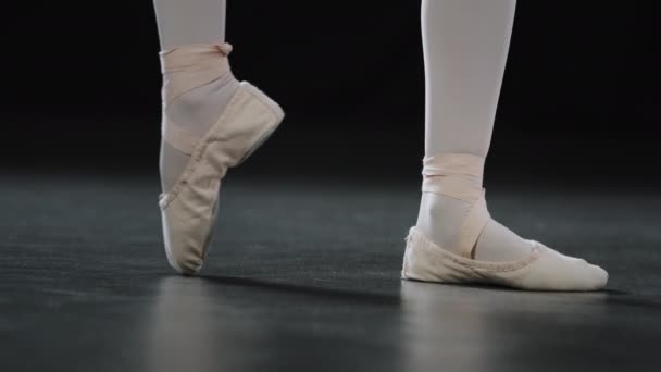 Unrecognizable girl ballerina dancer in pointe shoes for ballet on parquet floor on stage in dance class rehearsing performance does dancing exercise bending toes ankle stretching flexibility position - Séquence, vidéo