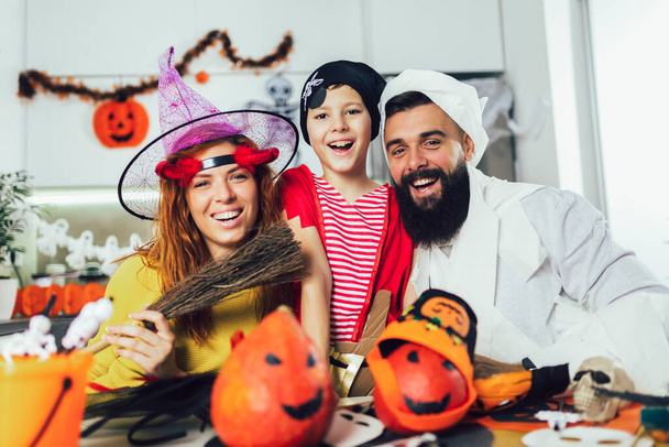 Happy family mother, father and son in costumes on a celebration of Halloween - Zdjęcie, obraz