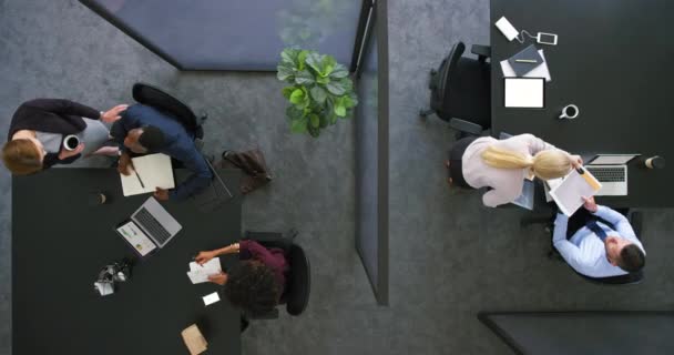 Colleagues collaborating to develop new ideas. A group of busy employees working together in a corporate office. Top view of a team of business people discussing and planning a project for a company - Πλάνα, βίντεο
