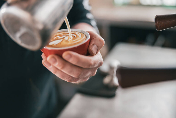 Barista pouring milk in glass of fresh made coffee making latte or cappuccino. High quality photo - Fotoğraf, Görsel