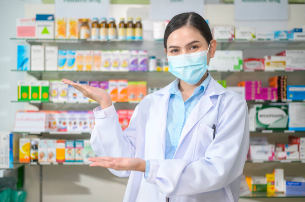 A Portrait of female pharmacist wearing face mask in a modern pharmacy drugstore. - Fotografie, Obrázek