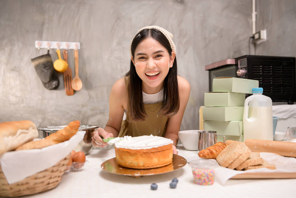 A Young beautiful woman is baking in her kitchen , bakery and coffee shop business - Photo, Image
