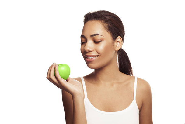 緑のリンゴを持っている美しい笑顔の女性。健康的なライフスタイル、栄養、食事、減量、歯科ケア、健康な歯の概念.  - 写真・画像