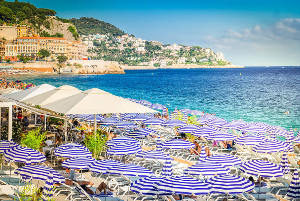 turquiose water of cote dAzur with striped beach umbrellas, summer Nice scenery - Fotoğraf, Görsel