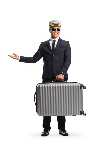 Pilot carrying a suitcase and gesturing with hand isolated on white background - Φωτογραφία, εικόνα