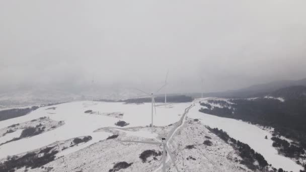Letecký pohled na větrnou farmu v zimě, rotující turbíny na zasněženém poli na Ukrajině - Záběry, video