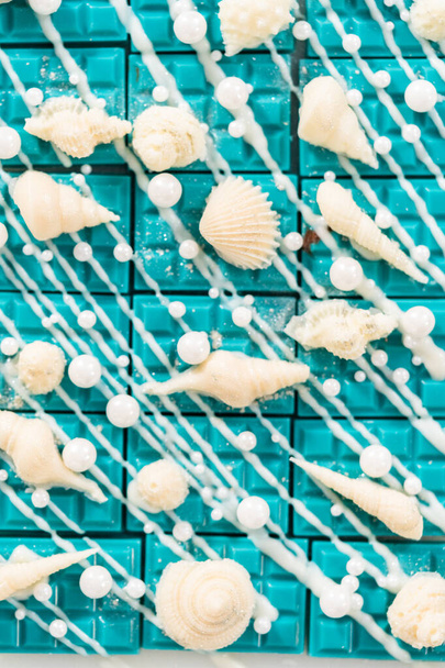 Mini mermaid chocolate bars drizzled with white chocolate, sprinkling with white pearl sugar sprinkles, and decorated with a white chocolate seashells. - Photo, Image