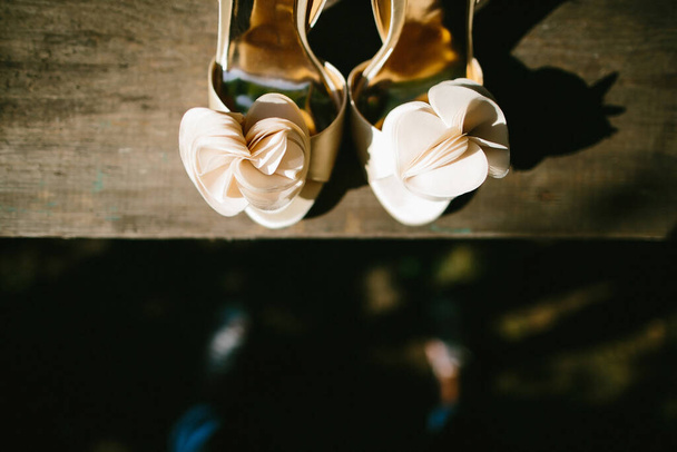 Zapatos de boda beige en un alféizar de ventana de madera. - Foto, imagen