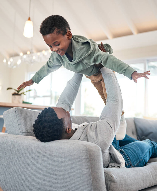 Who needs a workout when playtime is just as energetic. an adorable little boy having fun with his father on the sofa at home - Fotó, kép