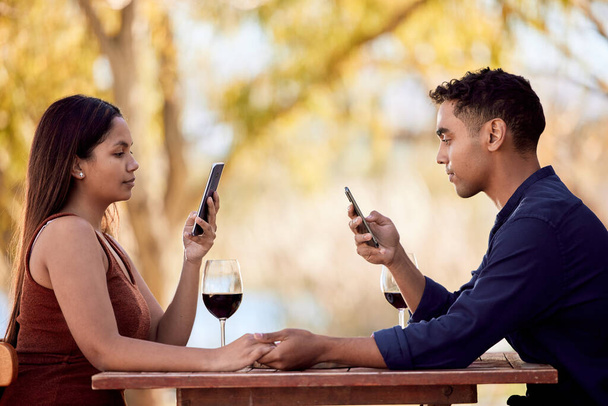 Ready for dinner with someone special. a young couple having wine on a date on a wine farm - Foto, immagini