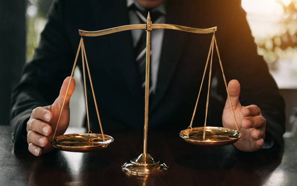 lawyer man in black suit with brass scale on wooden table. justice concept  - Фото, изображение