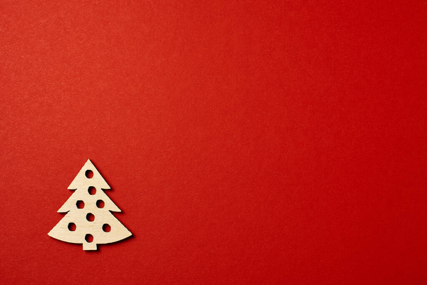 Christmas red background, with wooden Christmas trees. Minimalistic Christmas red background. Christmas background with toys top view on a red background. New Year card. - Foto, Bild