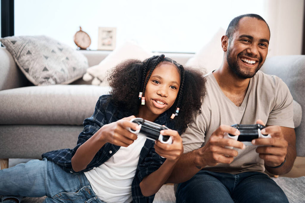 Youve met your match, dad. a young girl playing video games with her father at home - Fotó, kép