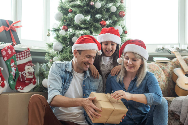 family having fun and playing together near Christmas tree indoors - 写真・画像