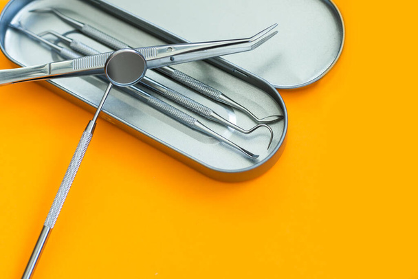 Professional Dentist tools in dental office: dentist mirror, forceps curved, explorer curved, dental explorer angular and explorer curved with chip, right. Dental Hygiene and Health. - Foto, Imagen