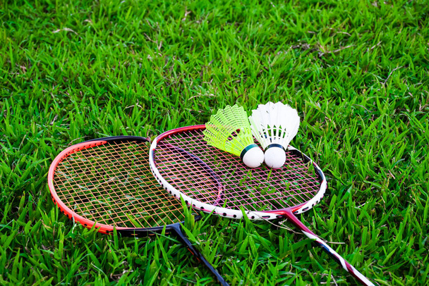 Shuttlecocks and badminton rackets on the green field - Foto, imagen
