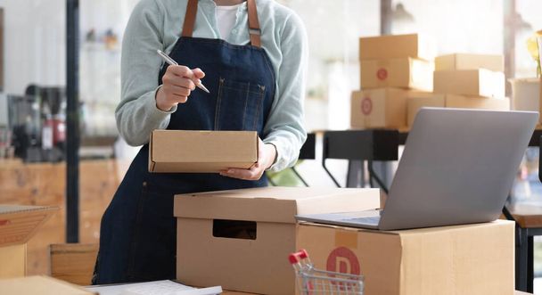 Startup Entrepreneurship Small Business SME Freelance Young lady working at home with boxes and laptop online Marketing Packaging SME Shipping Ecommerce Concept - Fotoğraf, Görsel