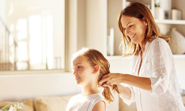 Ill help her for as long as I can. an attractive young mother bonding with her daughter by doing her hair in the morning - Φωτογραφία, εικόνα