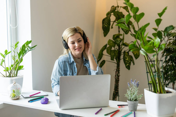 Foto van charmante positieve persoon zitten achter desktop look gebruik laptop hebben goed humeur werken thuis binnen. - Foto, afbeelding